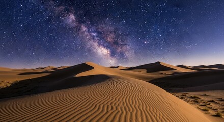 Majestic sand dunes under a clear night sky illuminated by the vibrant Milky Way galaxy in a desert landscape.