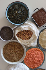 Bowls and bags full of various healthy grains and legumes. Top view.