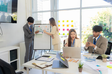 Marketing concept with laptop in office, Asian business group teamwork brainstorming meeting and discussing strategy, financial analysis, successful plan.