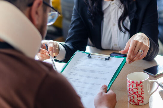 Young lawyer showing a document paper to a male client.
