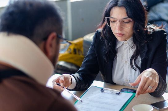 Young lawyer showing a document paper to a male client, insurance, legal contract or lawyer consulting. Disability people, attorney or advocate in negotiation, policy advice or accident report