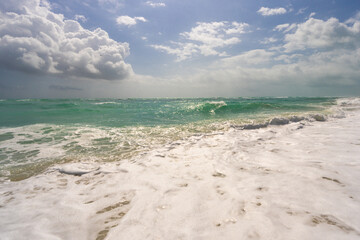 Fototapeta premium Sea background. Blue ocean. Sandy sea beach. Ocean waves. Summer seaside. Tropical sea coastline. Exotic turquoise water. Foamy wave splash on sea. Sunny beach view.