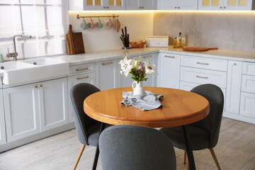 Dining table, chairs and floral decor in kitchen. Interior design