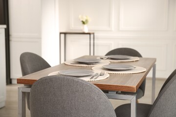Stylish table setting and chairs in dining room. Interior design