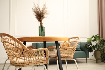 Wooden table with decor and stylish chairs in dining room