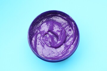 Care cosmetic product for blonde hair in jar on light blue background, top view