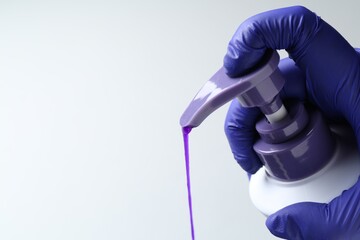 Woman pouring hair care product for blonde hair from bottle on white background, closeup. Space for text