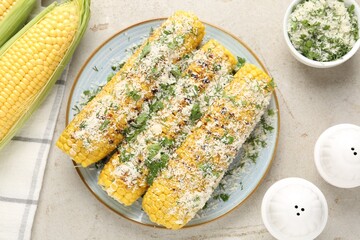 Tasty grilled corncobs with parsley and cheese on light table, flat lay