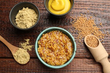 Different types of mustard on wooden table, flat lay