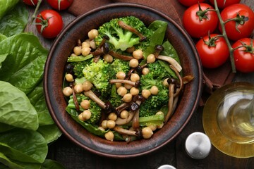 Delicious salad with shimeji mushrooms, chickpeas and broccoli served on wooden table, flat lay