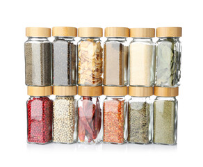 Different aromatic spices in glass jars isolated on white