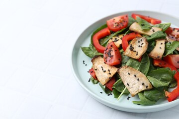 Tasty salad with eryngium mushrooms, vegetables, spinach and sesame on white tiled table, closeup. Space for text