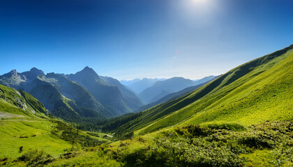 Obraz premium Majestic Mountain Landscape With Lush Greenery And Clear Blue Sky Under Bright Sunlight