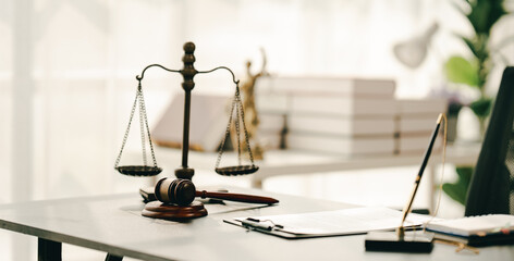 law firm courtroom Law books, computer and scales of justice on table in lawyer office