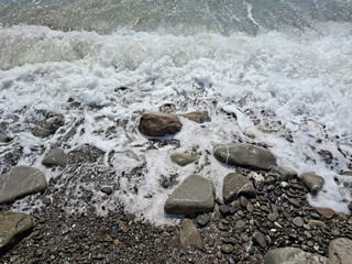beautiful close-up of a stone lapped by the foaming waves on the seashore