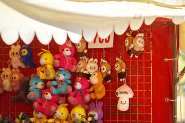Bright toy shop stand with colorful plush toys on red background.