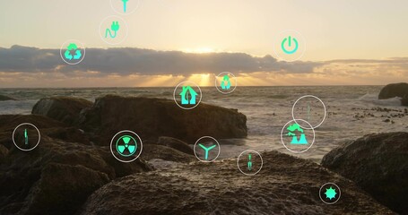 Floating circular badges displaying green energy icons over volcanic rocks by sea at sunset