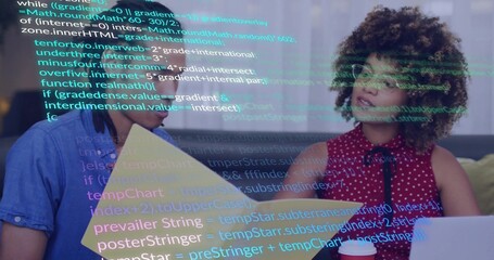 Coworkers reviewing code overlay on office grey sofa, holding yellow folder laptop red coffee cup