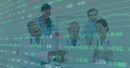 Analyzing metrics on laptop, team wearing scrubs, stethoscopes in conference room with data overlay