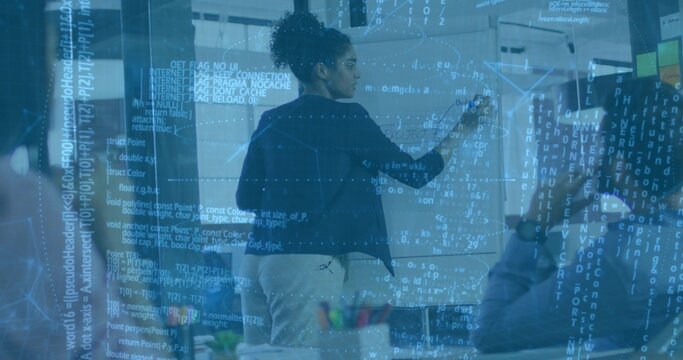 Businesswoman in black blazer writing on whiteboard in conference room, with laptop, sticky notes