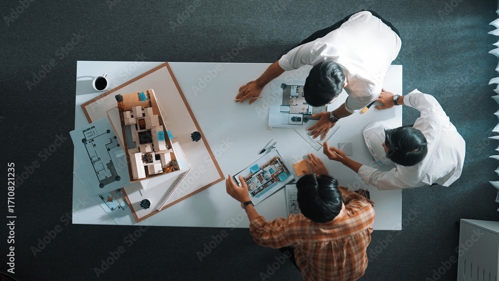 Poster group of skilled designer looking at model while discussing about building. top view of architect en