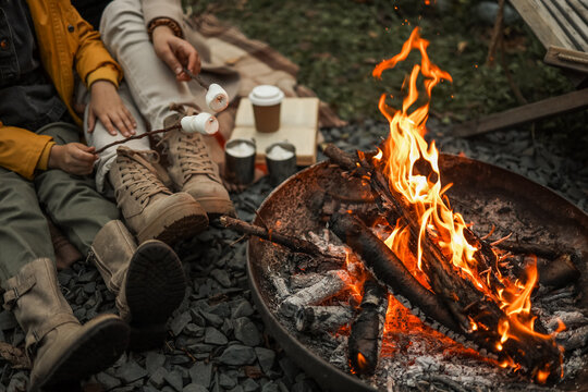 Cozy campfire scene with marshmallows roasting over the flames