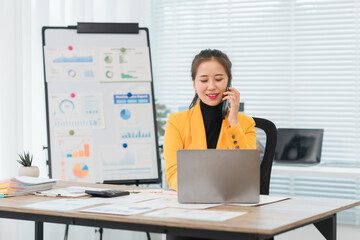 Asian Businesswoman Working with Laptop and Talking on Phone