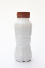 A white plastic bottle containing milk on a white background.