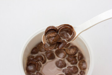 A bowl of chocolate cereal with chocolate milk on a white background. Delicious nutritious Breakfast for the child