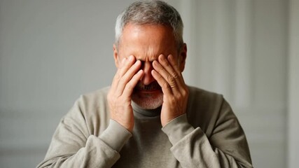 Portrait of a senior man suffering from a headache