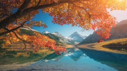 Vibrant autumn landscape with a calm lake reflecting snowcapped mountains and a tree with orange leaves