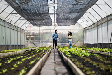 Mother teaching daughter gardening in greenhouse, Learn practical skills with mother while using...