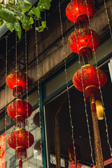 Traditional red Chinese lanterns with lights hanging in a shop window in Chinatown