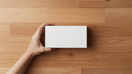 Obraz premium Hand holding white box on wood rectangular