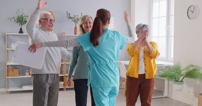 Caregiver interacts with elderly patients in a nursing home, offering high fives and embraces. Providing care, emotional support, and fostering a compassionate treatment environment. - Powered by Adobe