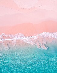 Fototapeta premium An aerial shot of a stunning pink sand beach meeting crystal clear turquoise waters, with gentle waves lapping the shore