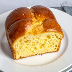 French Brioche Bread with Golden Crust and Soft Buttery Texture Served on White Plate for Premium Bakery Object and Gourmet Food Concept