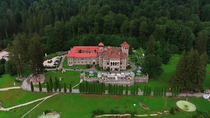 Going up over the beautiful territory of the Cantacuzino Castle in Busteni, Romania. Tourists walk by the landmark.