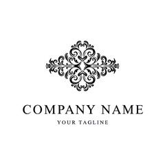 A classic black and white logo design featuring an ornate, symmetrical flourish above the text 