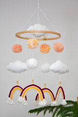 Handmade rainbow baby mobile with felt clouds and pom poms