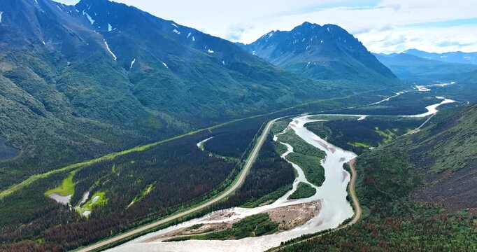 River delta with winding streams in Alaska mountains. Aerial view of a braided river system flowing through mountain valleys in Alaska.