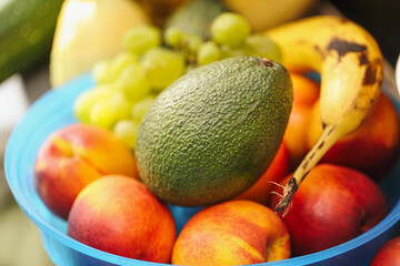 Bowl full of fresh fruits. Avocado banana grapes and peaches. Natural vitamins and minerals for healthy lifestyle. Organic diet and nutrition. Daily energy from fruits at home.