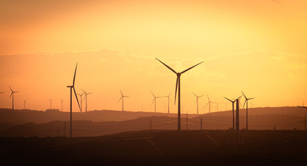 Obraz premium Windmill turning with sky in the background and sunset