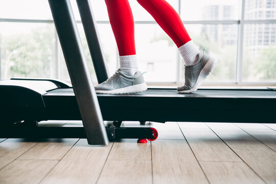 Focused athlete on treadmill in sleek gym interior during workout