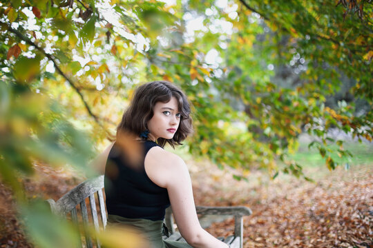  Profile of a young woman sitting at a park bench