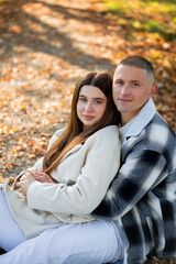 Portrait of a young happy couple in love in an autumn yellow park. Enjoying life.