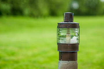 Rustic outdoor light fixture in grassy area.
