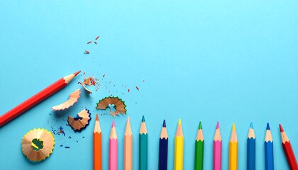 Colorful pencils arranged in a row on a light blue background, with shavings scattered nearby, demonstrating vibrant creativity and education.