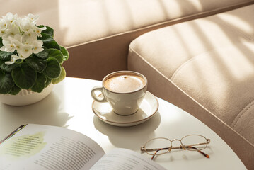 Cozy Living Room with Coffee, Book and African Violet on Table