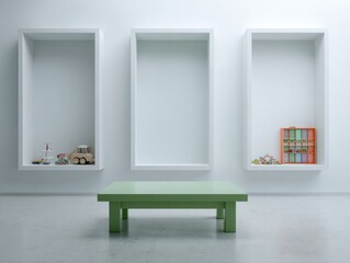 A modern, minimalist room displays three recessed display areas, each holding small toys, against a bright white wall, with a simple green table in the center.
